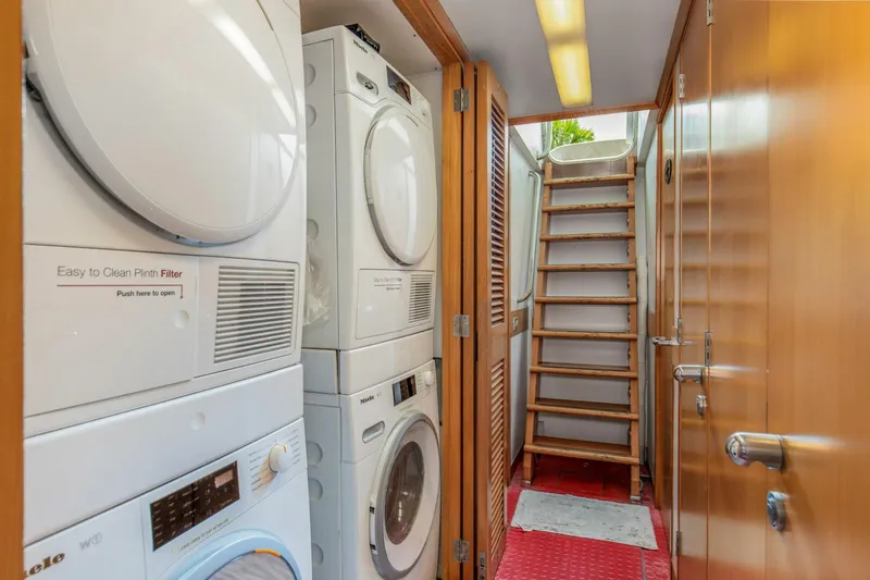 Boss Yacht Photos Pics Laundry room with stacked washers and dryers on a 1989 Feadship 116 Sport Fisher yacht.