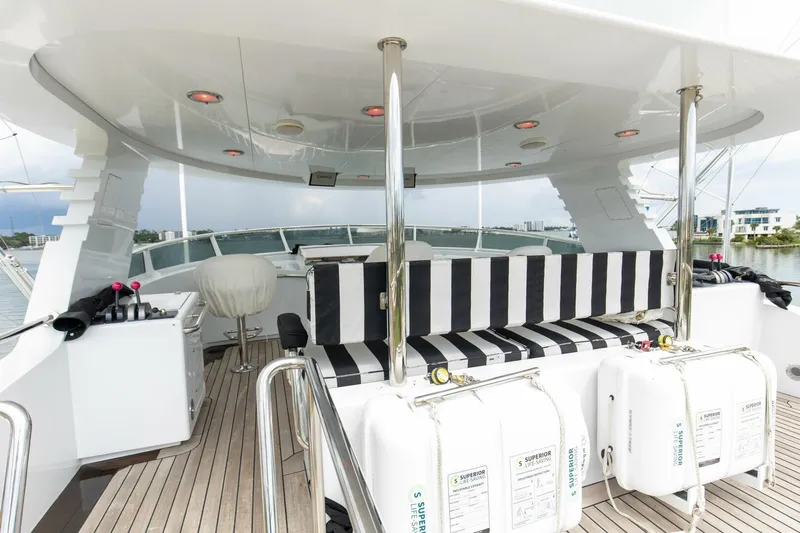 Boss Yacht Photos Pics Luxurious 1989 Feadship 116 Sport Fisher yacht deck with striped seating and life rafts.