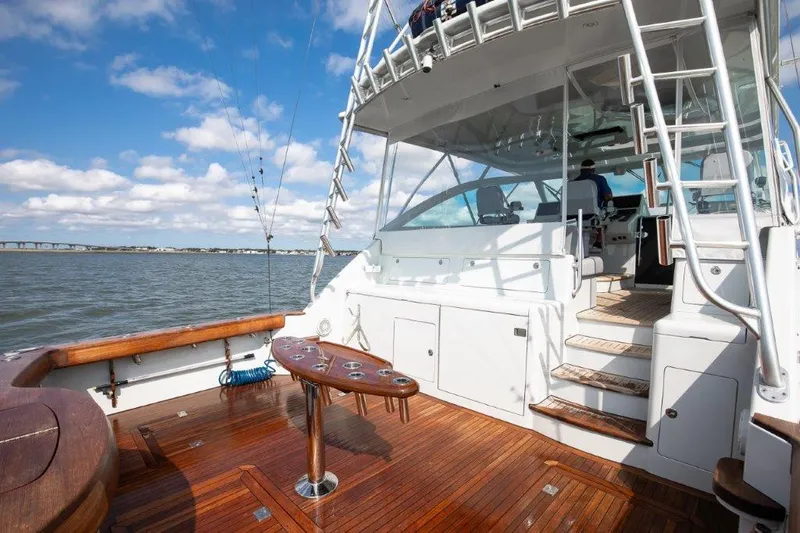 Reel Blessed Yacht Photos Pics 2006 Cabo 52 Open yacht with wooden deck, fishing rods, and clear sky.