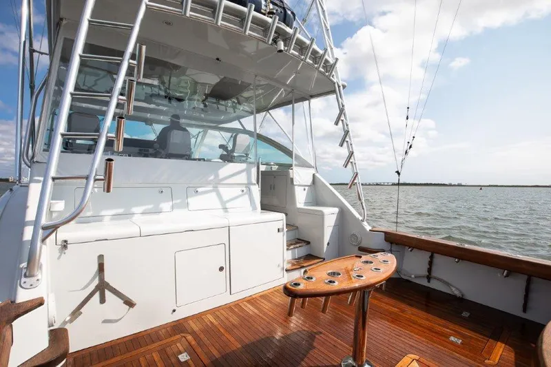 Reel Blessed Yacht Photos Pics 2006 Cabo 52 Open yacht with wooden deck and fishing rod holders on a sunny day.