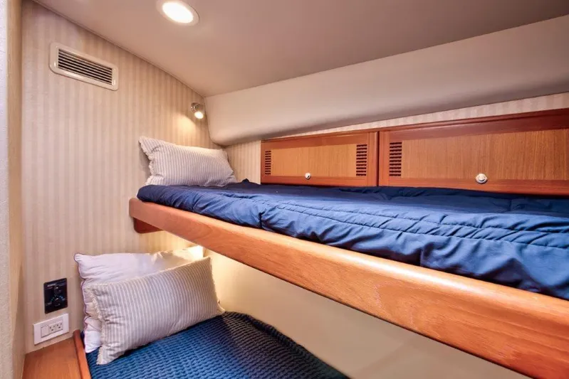 Reel Blessed Yacht Photos Pics Bunk beds in 2006 Cabo 52 Open yacht cabin with blue bedding and wooden accents.