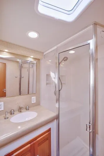 Reel Blessed Yacht Photos Pics Luxurious bathroom in 2006 Cabo 52 Open yacht with modern fixtures and glass shower.