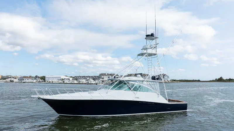 Reel Blessed Yacht Photos Pics 2006 Cabo 52 Open yacht on water, clear sky, coastal background.