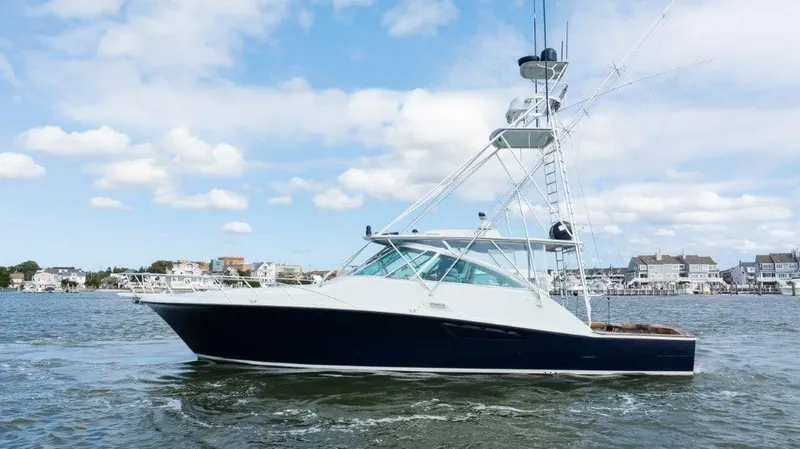 Reel Blessed Yacht Photos Pics 2006 Cabo 52 Open yacht cruising on a sunny day near coastal homes.