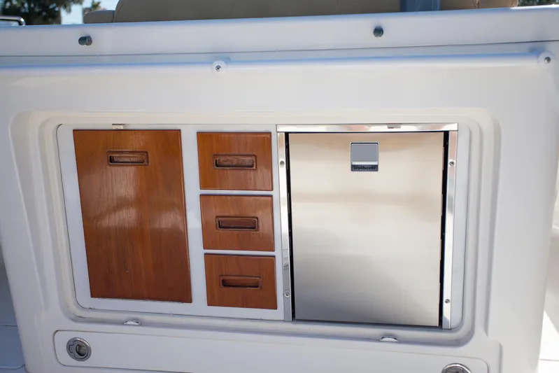  Yacht Photos Pics 2012 Contender 39 LS boat interior with wooden storage cabinets and stainless steel fridge.