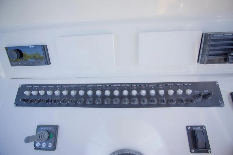  Yacht Photos Pics Control panel of a 2012 Contender 39 LS boat with various switches and dials.