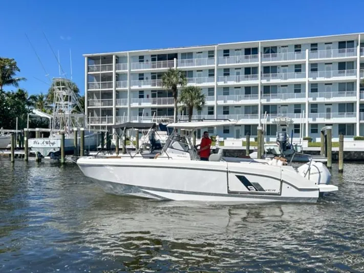  Yacht Photos Pics 2024 Beneteau Flyer 9 SPACEdeck boat cruising near waterfront building.