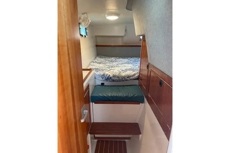 On The Fly Yacht Photos Pics 2005 PDQ 34 Power Catamaran cabin interior with bed, wooden accents, and compact design.