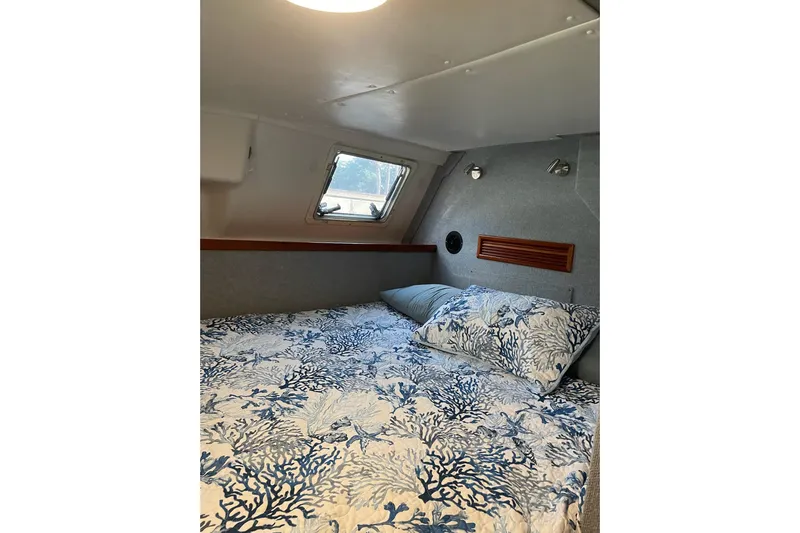 On The Fly Yacht Photos Pics Cozy cabin interior of 2005 PDQ 34 Power Catamaran with nautical-themed bedding.