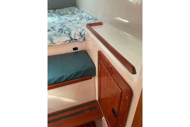 On The Fly Yacht Photos Pics Interior cabin of 2005 PDQ 34 Power Catamaran with wooden accents and bedding.