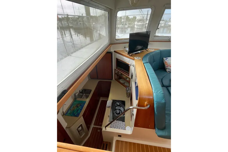 On The Fly Yacht Photos Pics Interior of 2005 PDQ 34 Power Catamaran with kitchen, seating, and TV.