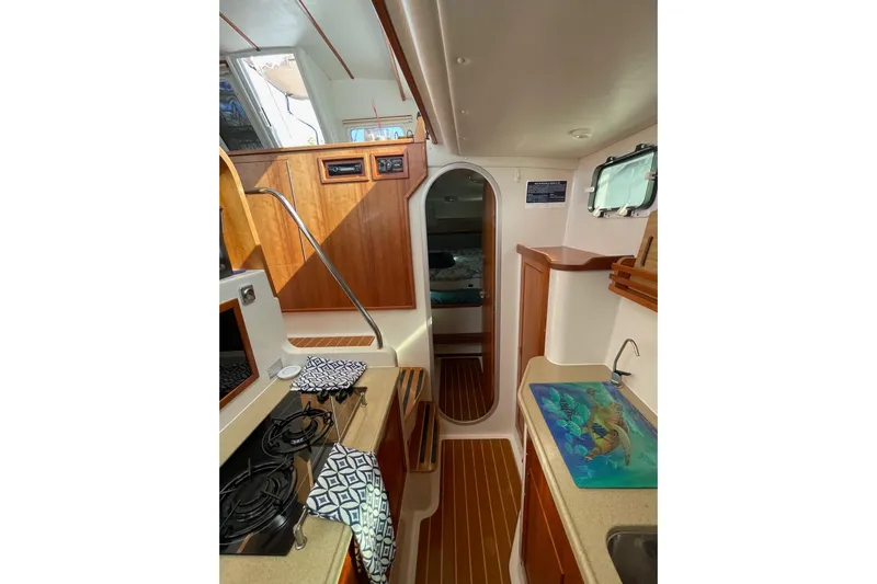 On The Fly Yacht Photos Pics Interior of 2005 PDQ 34 Power Catamaran with kitchen and wooden cabinetry.