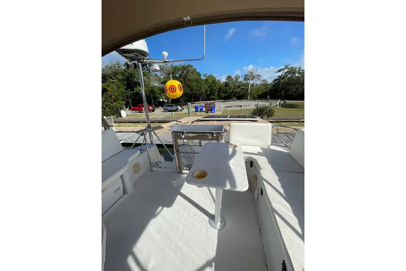 On The Fly Yacht Photos Pics 2005 PDQ 34 Power Catamaran deck with seating and table, docked near trees.