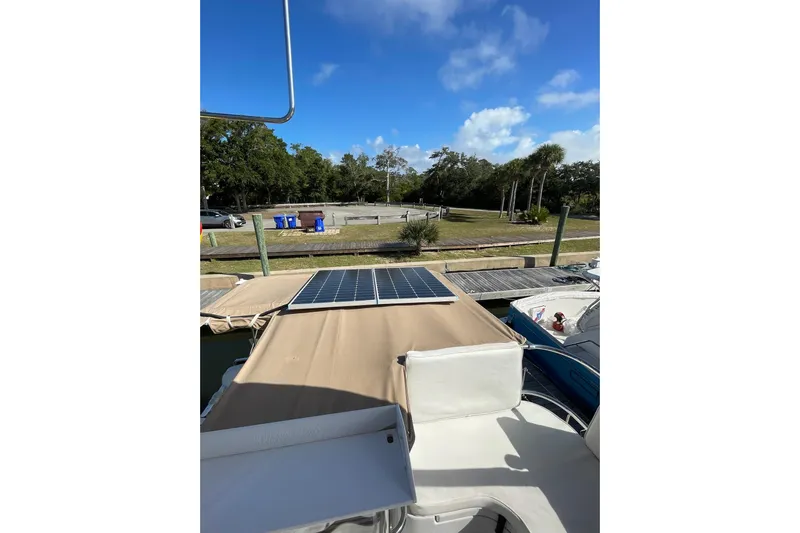 On The Fly Yacht Photos Pics 2005 PDQ 34 Power Catamaran with solar panels docked under clear blue sky.