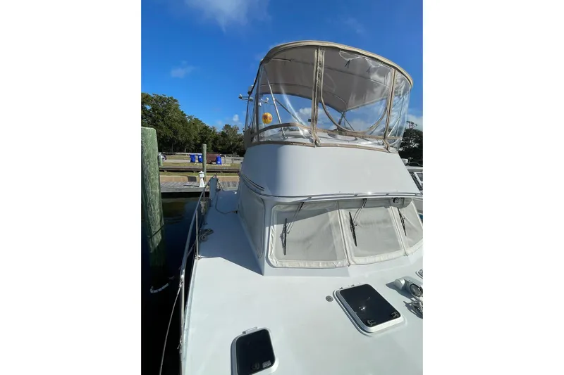 On The Fly Yacht Photos Pics 2005 PDQ 34 Power Catamaran docked, featuring a covered helm and sleek design.