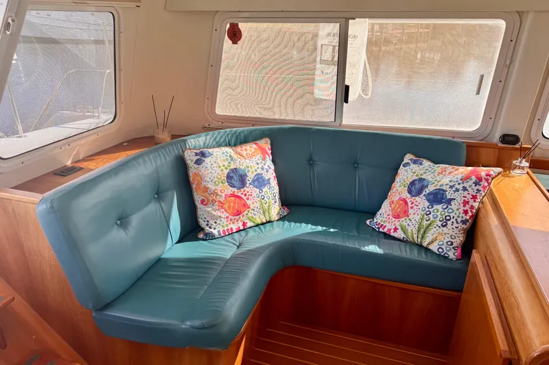 On The Fly Yacht Photos Pics Interior of 2005 PDQ 34 Power Catamaran with blue seating and colorful cushions.