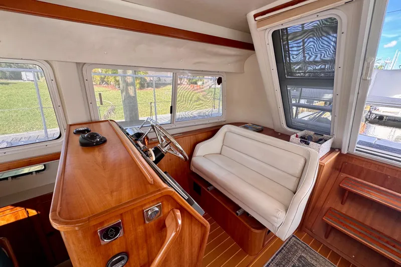 On The Fly Yacht Photos Pics 2005 PDQ 34 Power Catamaran interior with helm, white seating, and wooden accents.