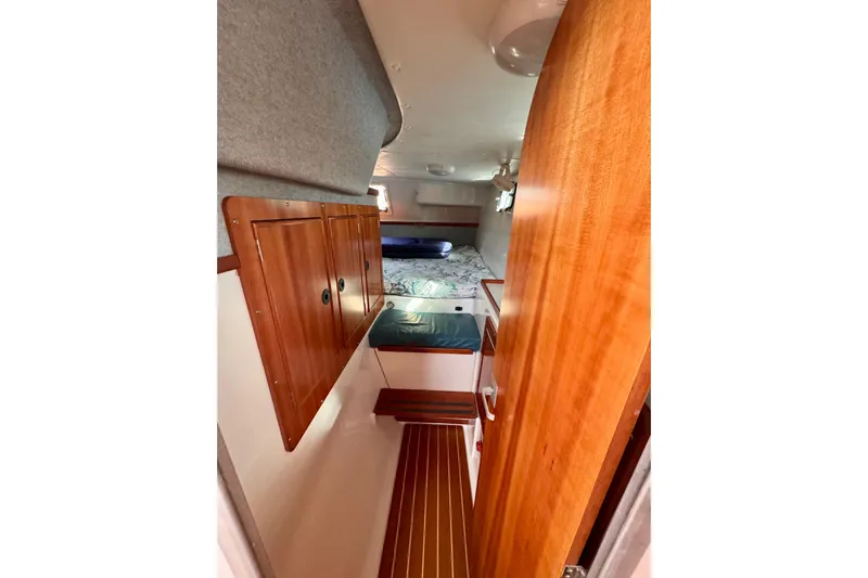 On The Fly Yacht Photos Pics 2005 PDQ 34 Power Catamaran interior with wooden cabinetry and cozy sleeping area.