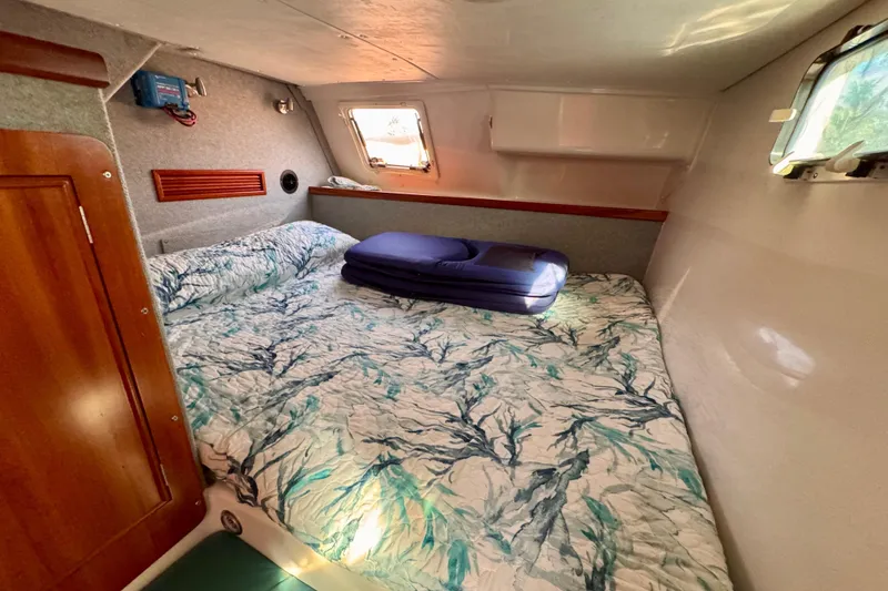 On The Fly Yacht Photos Pics Cozy cabin interior of 2005 PDQ 34 Power Catamaran with patterned bedding and natural light.