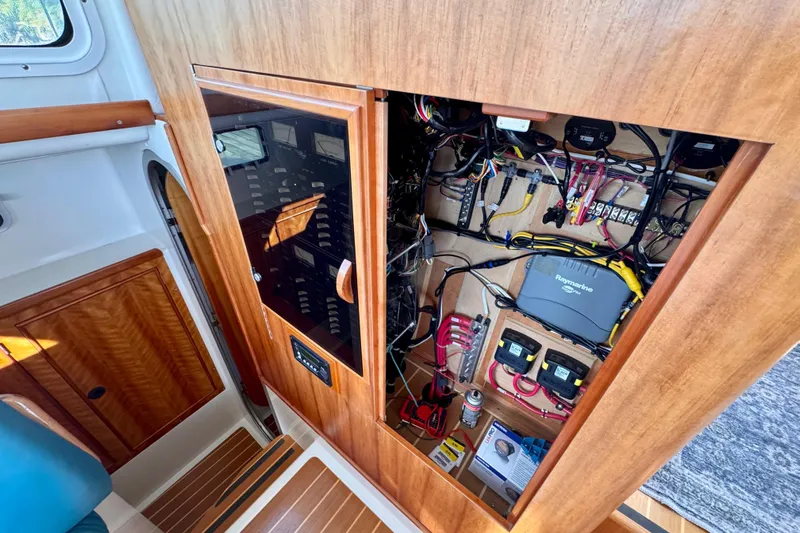On The Fly Yacht Photos Pics Electrical panel and wiring inside a 2005 PDQ 34 Power Catamaran, showcasing organized components.