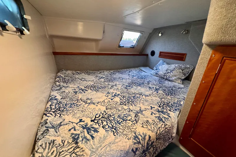 On The Fly Yacht Photos Pics Cozy cabin interior of 2005 PDQ 34 Power Catamaran with nautical-themed bedding.