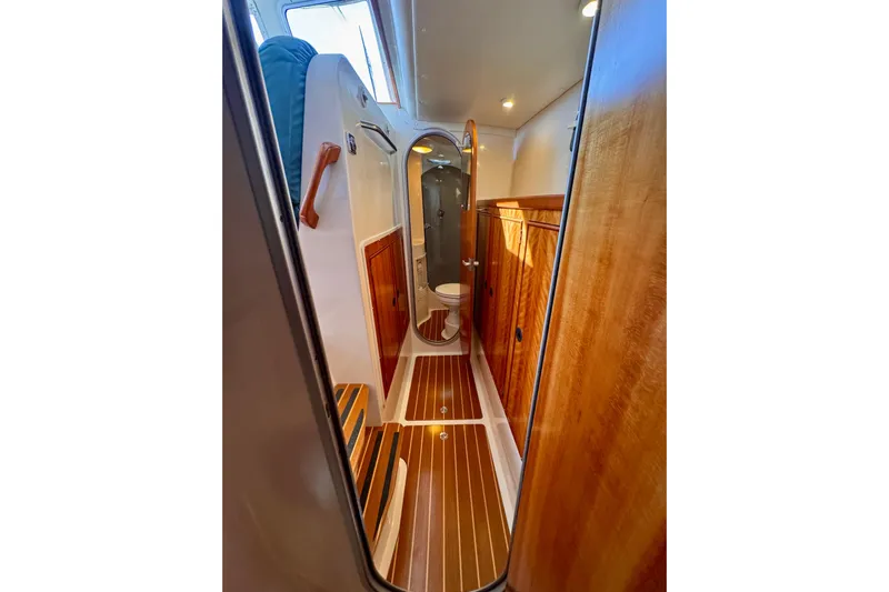 On The Fly Yacht Photos Pics 2005 PDQ 34 Power Catamaran interior with wooden cabinetry and compact bathroom.