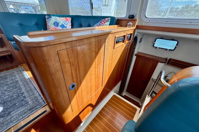 On The Fly Yacht Photos Pics Interior of 2005 PDQ 34 Power Catamaran with wood cabinetry and teal seating.