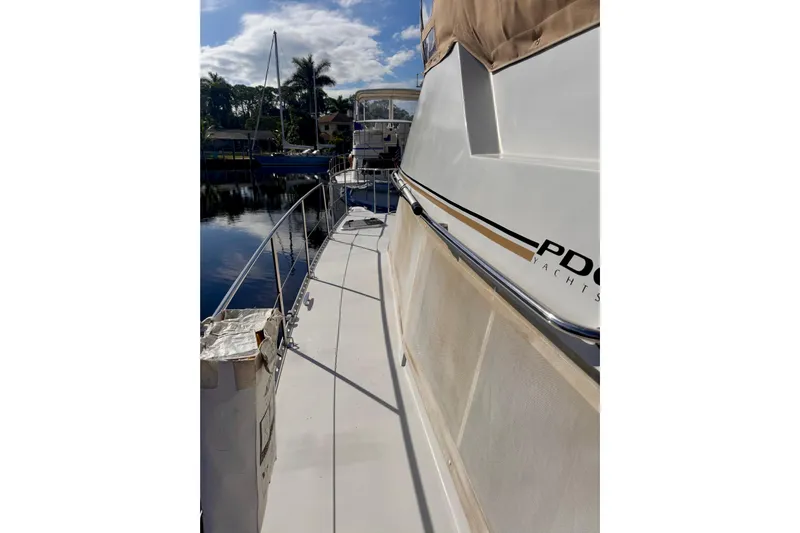 On The Fly Yacht Photos Pics 2005 PDQ 34 Power Catamaran docked, showcasing sleek design and spacious deck.