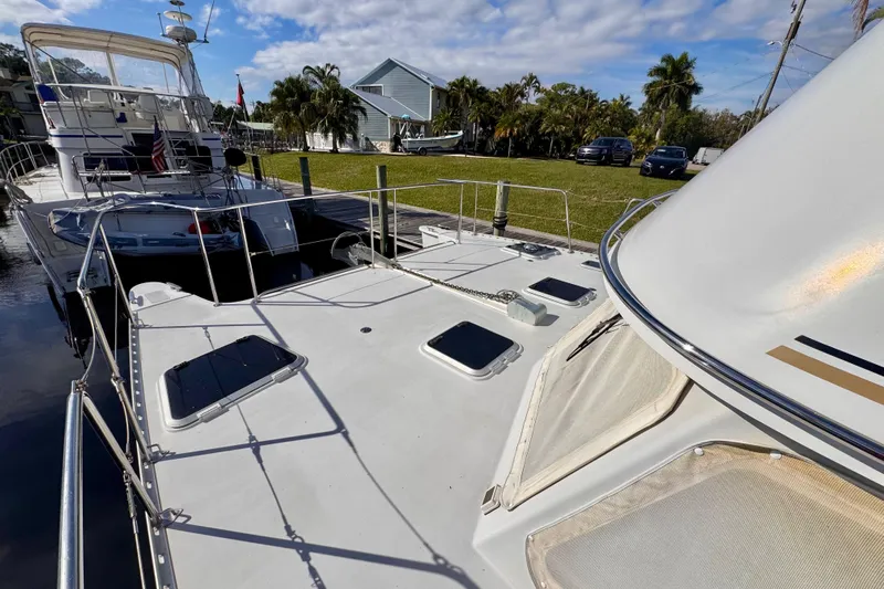 On The Fly Yacht Photos Pics 2005 PDQ 34 Power Catamaran docked, showcasing spacious deck and sleek design.