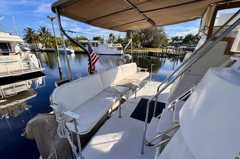 On The Fly Yacht Photos Pics 2005 PDQ 34 Power Catamaran docked, featuring spacious seating and canopy, with scenic marina view.
