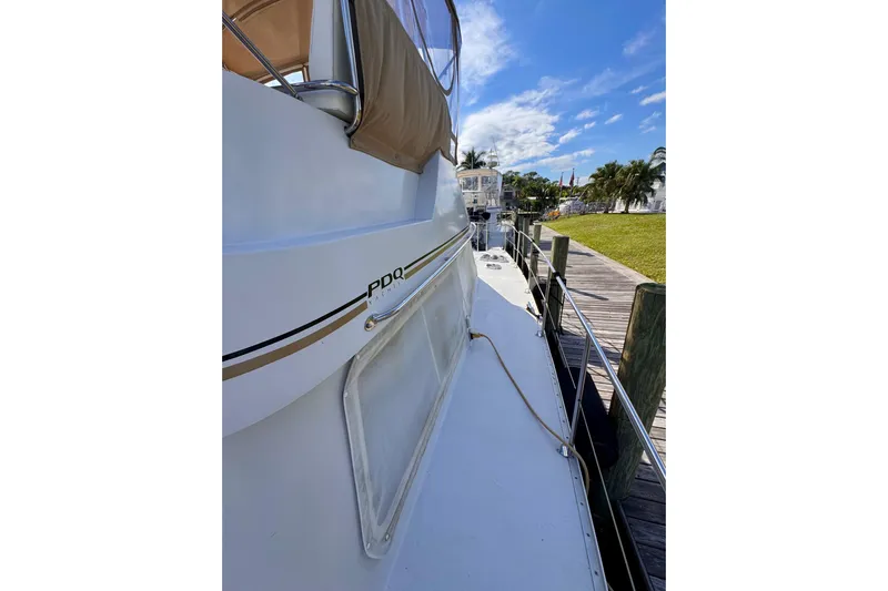 On The Fly Yacht Photos Pics 2005 PDQ 34 Power Catamaran docked, showcasing sleek design and spacious deck.