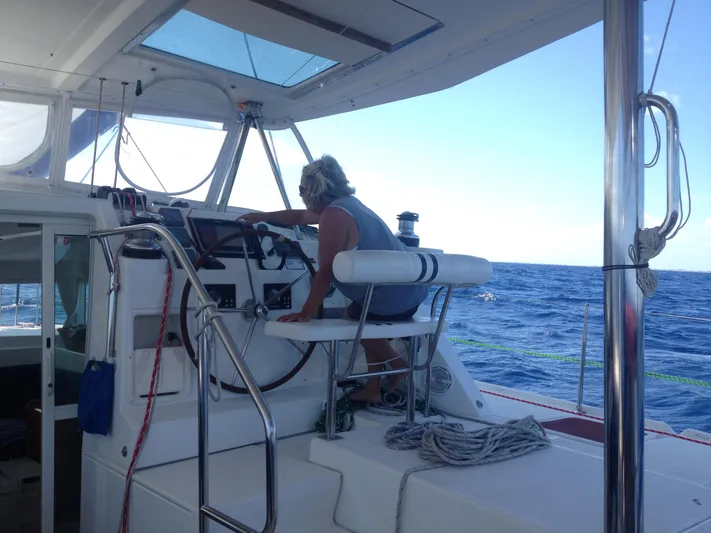 Rollercoaster Yacht Photos Pics Person navigating Lagoon 420 catamaran on open sea.