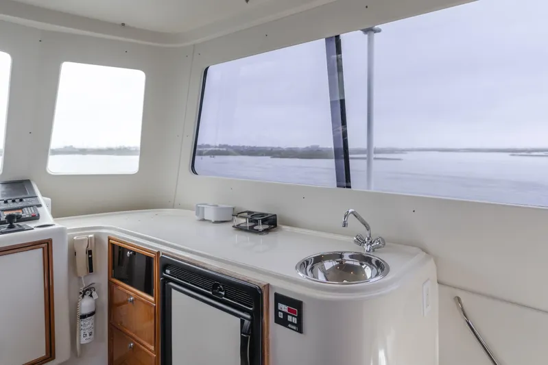 Pole Dancer Yacht Photos Pics Interior of 2005 Mediterranean 54 yacht with sink, cabinets, and ocean view.