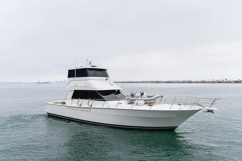 Pole Dancer Yacht Photos Pics 2005 Mediterranean 54 yacht cruising on calm waters under a cloudy sky.