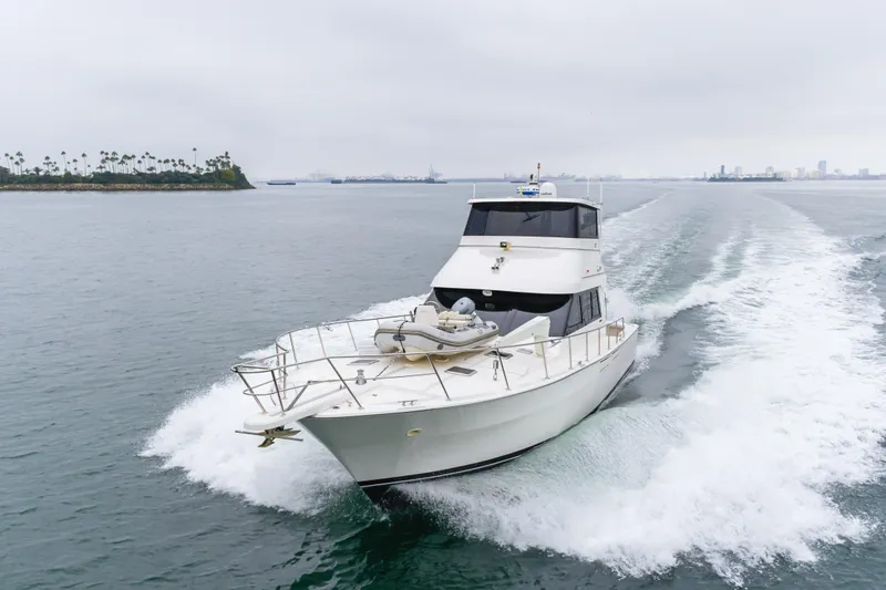 Pole Dancer Yacht Photos Pics 2005 Mediterranean 54 yacht cruising on open water with city skyline in background.