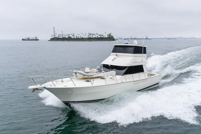 Pole Dancer Yacht Photos Pics 2005 Mediterranean 54 yacht cruising near an island on a cloudy day.