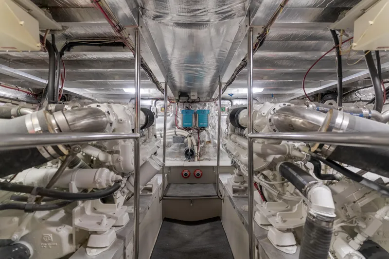 Pole Dancer Yacht Photos Pics Engine room of a 2005 Mediterranean 54 yacht, showcasing dual engines and metallic piping.
