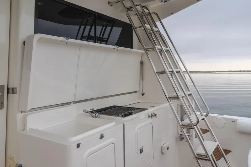 Pole Dancer Yacht Photos Pics Outdoor kitchen and ladder on a 2005 Mediterranean 54 yacht, overlooking calm waters.