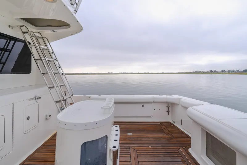 Pole Dancer Yacht Photos Pics Spacious deck of 2005 Mediterranean 54 yacht with wooden flooring and serene water view.