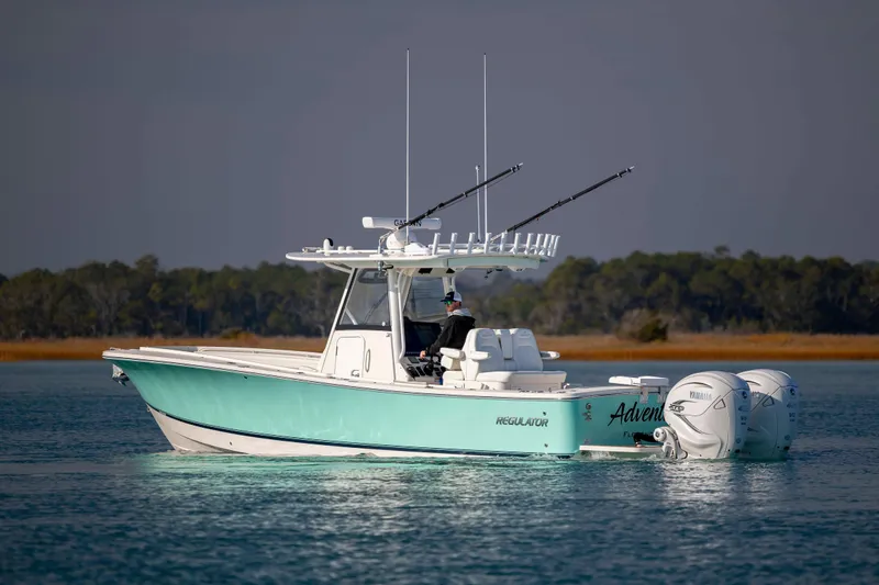  Yacht Photos Pics 2022 Regulator 31 boat on calm water with fishing rods and twin Yamaha engines.