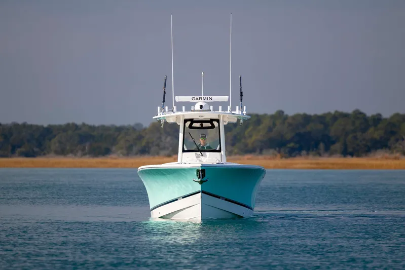  Yacht Photos Pics 2022 Regulator 31 boat on calm water with forested shoreline in background.