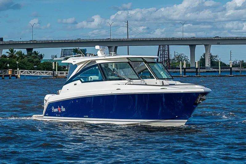 Prawn Star Yacht Photos Pics 2022 Tiara Yachts 34 LX cruising on a sunny day near a bridge.