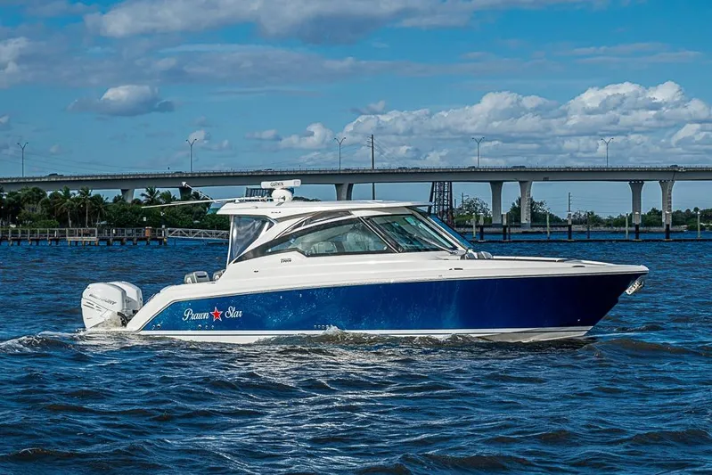 Prawn Star Yacht Photos Pics 2022 Tiara Yachts 34 LX cruising on a sunny day with a bridge in the background.