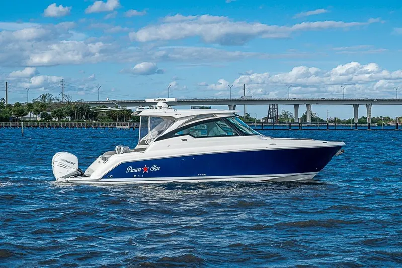 Prawn Star Yacht Photos Pics 2022 Tiara Yachts 34 LX cruising on a sunny day with a bridge in the background.