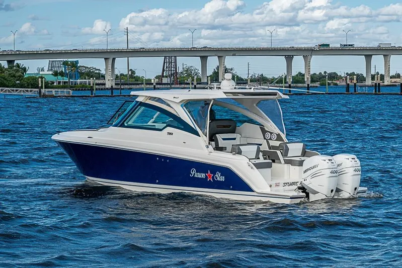 Prawn Star Yacht Photos Pics 2022 Tiara Yachts 34 LX cruising on a sunny day near a bridge.