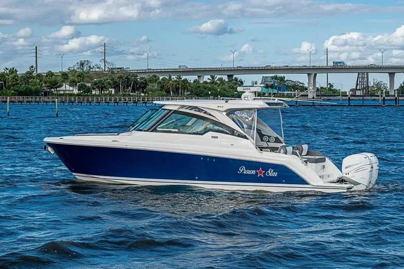 Prawn Star Yacht Photos Pics 2022 Tiara Yachts 34 LX cruising on a sunny day near a bridge.