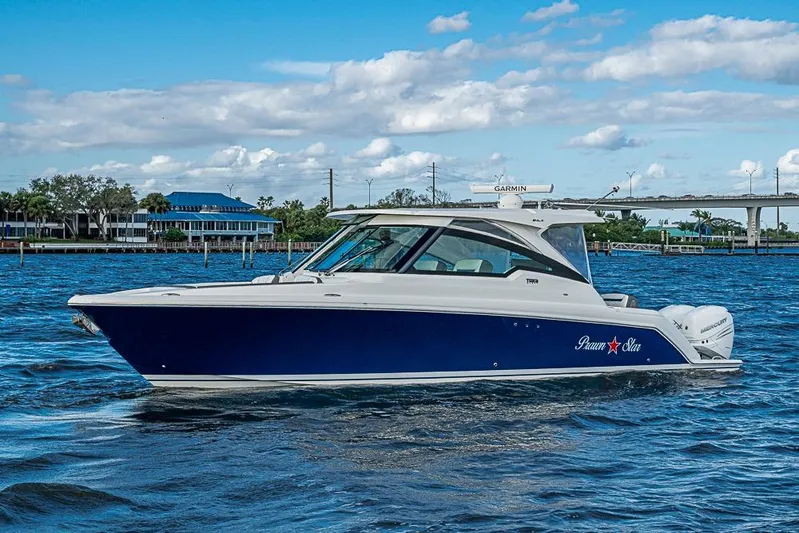 Prawn Star Yacht Photos Pics 2022 Tiara Yachts 34 LX cruising on a sunny day with scenic waterfront backdrop.