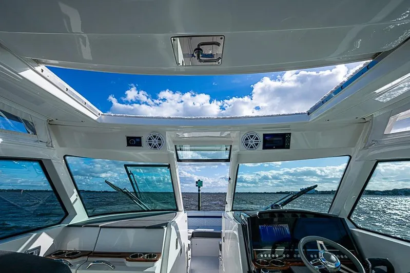 Prawn Star Yacht Photos Pics Interior view of 2022 Tiara Yachts 34 LX, showcasing helm and panoramic windows.