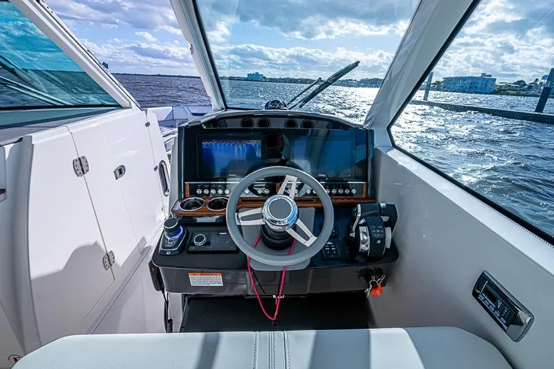 Prawn Star Yacht Photos Pics Cockpit view of 2022 Tiara Yachts 34 LX, featuring modern controls and scenic water backdrop.