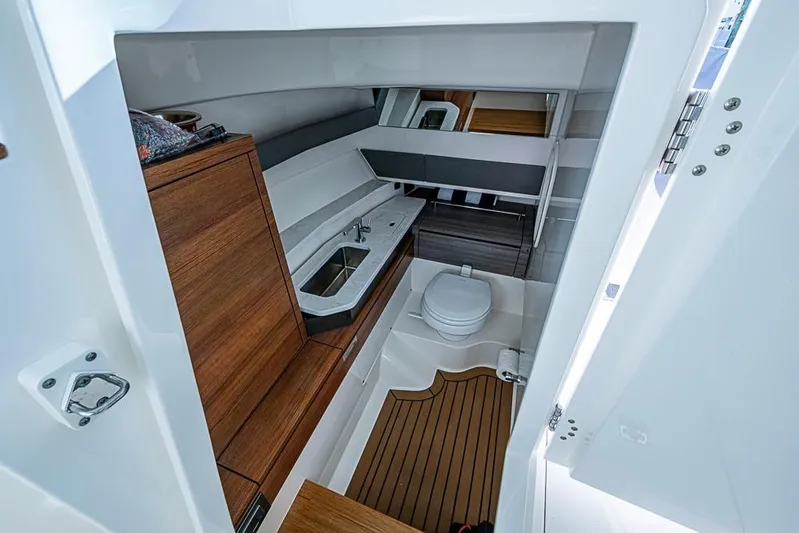Prawn Star Yacht Photos Pics 2022 Tiara Yachts 34 LX interior with wooden cabinetry, sink, and toilet.